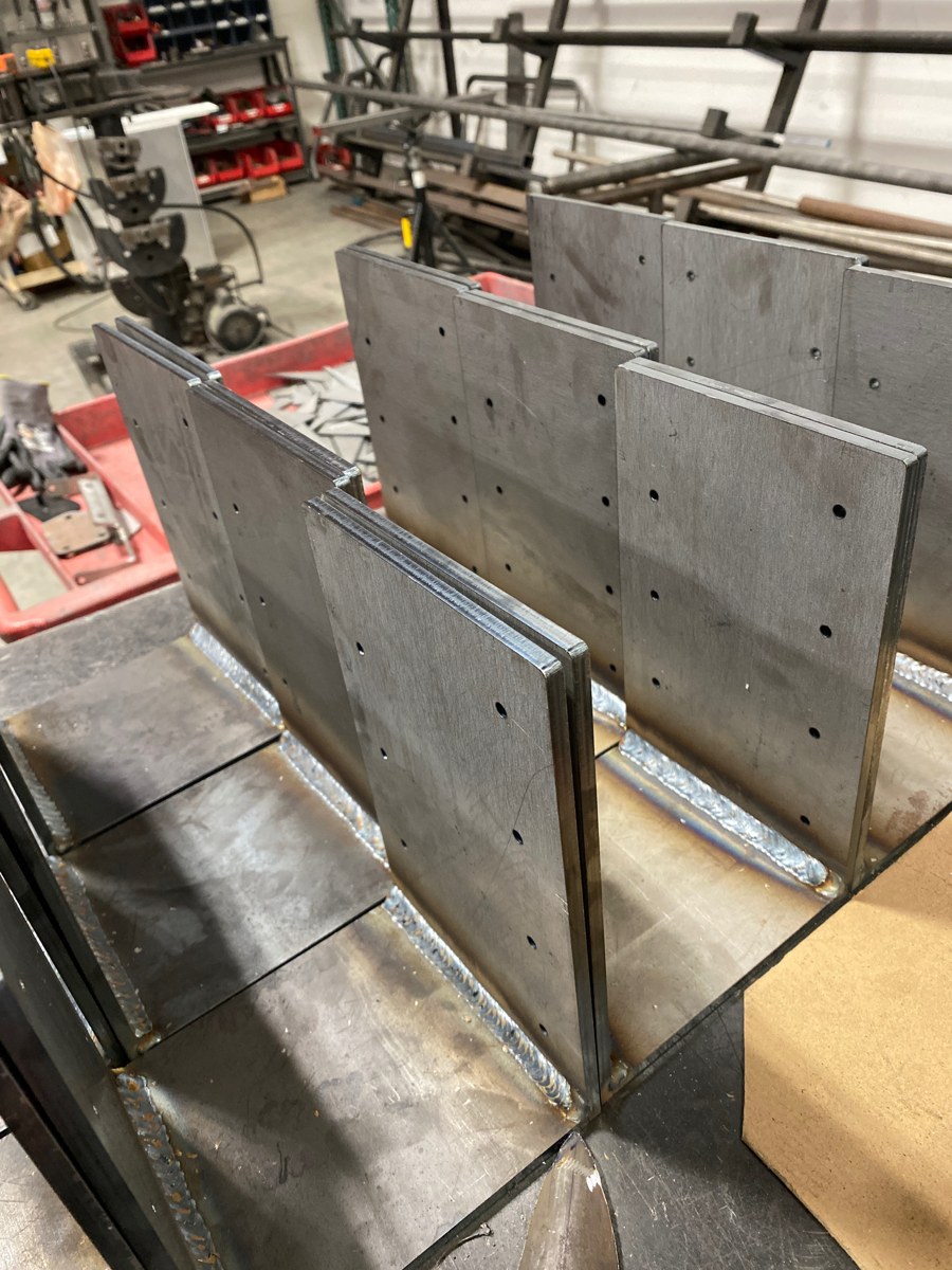 Welded plate brackets with machined mounting holes